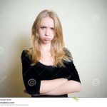young-blonde-woman-angry-sullen-portrait-attractive-looking-camera-face-expression-sulky-offended-peevish-clear-wall-79432741